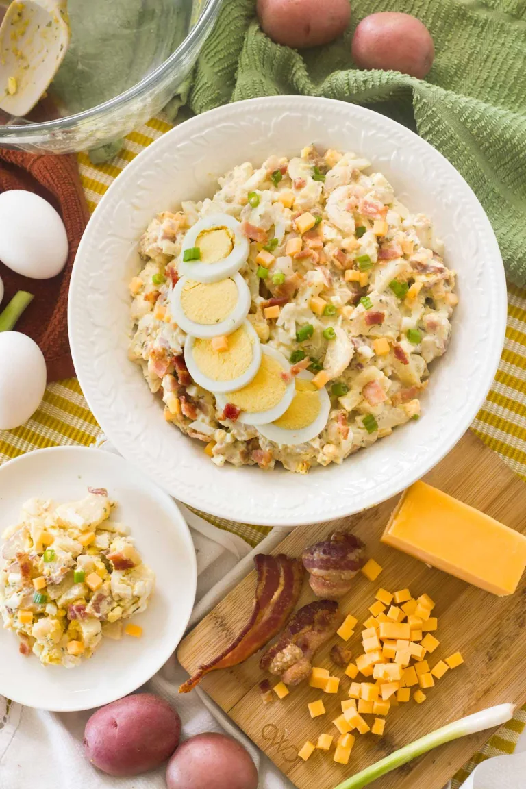 Bacon ranch potato salad with sliced eggs in a white bowl.