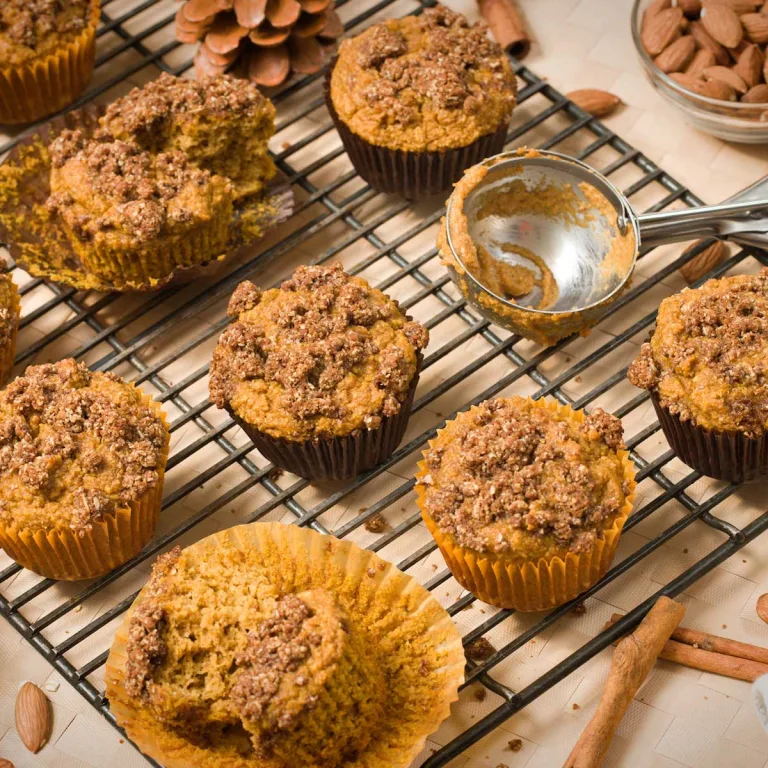 Gluten-free pumpkin muffins with oat cinnamon streusel on top on a cooling rack.
