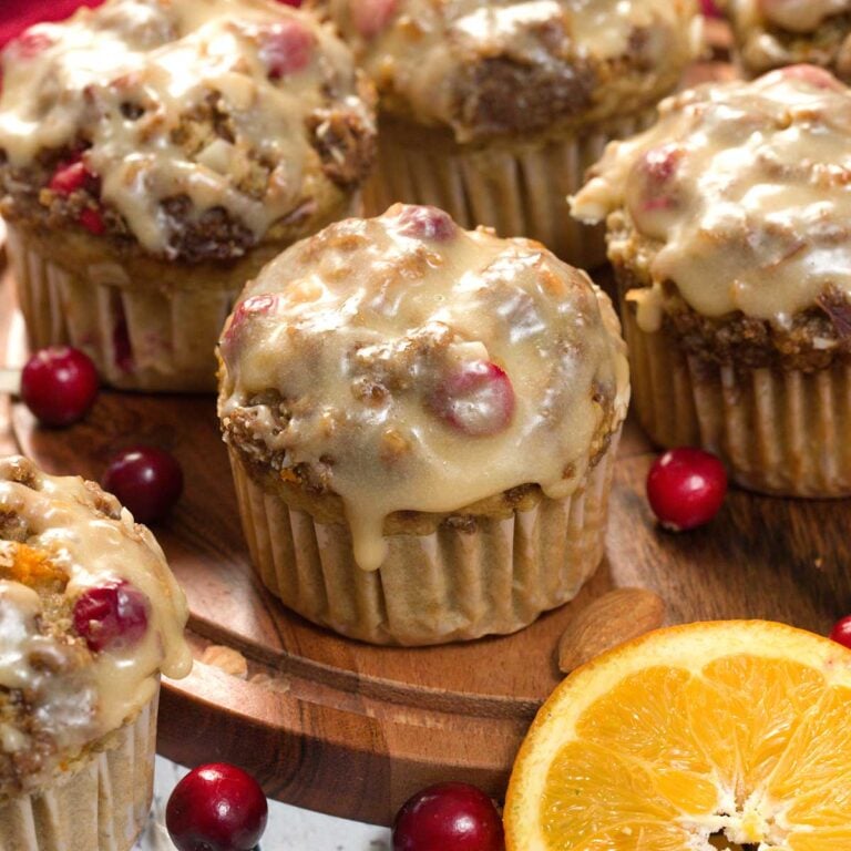 Gluten-Free Glazed Cranberry Orange Muffins on a kitchen counter.