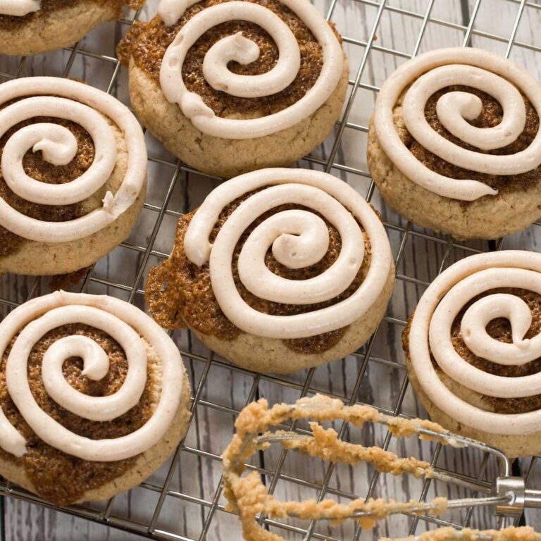 Gluten-Free Copycat Crumbl Cinnamon Roll Cookies with cream cheese frosting on a kitchen counter.