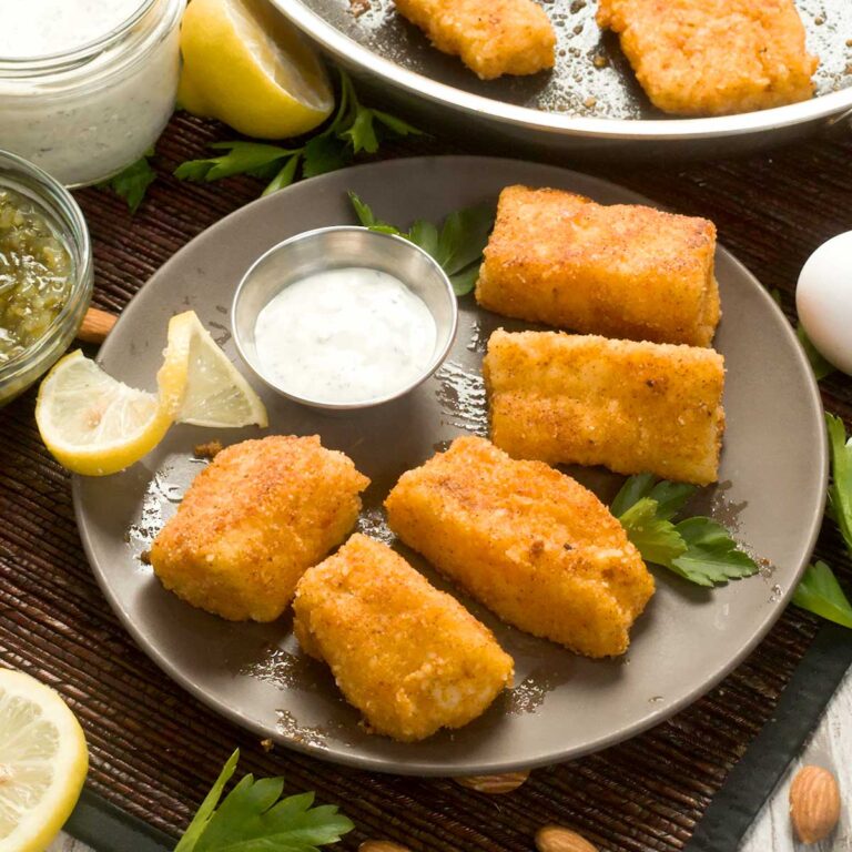 Pan-fried cod on a plate with greek yogurt tartar sauce.