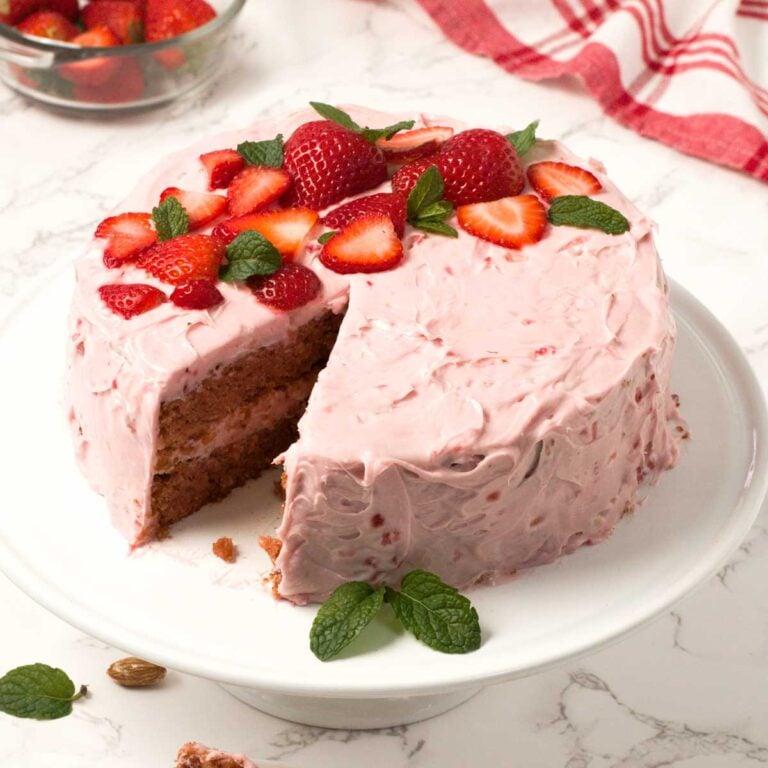 Gluten-Free Strawberry Cake with Cream Cheese Frosting on a cake plate.