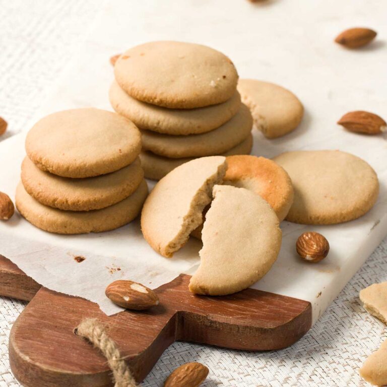A stack of almond flour gluten-free vanilla wafer cookies on a white board.