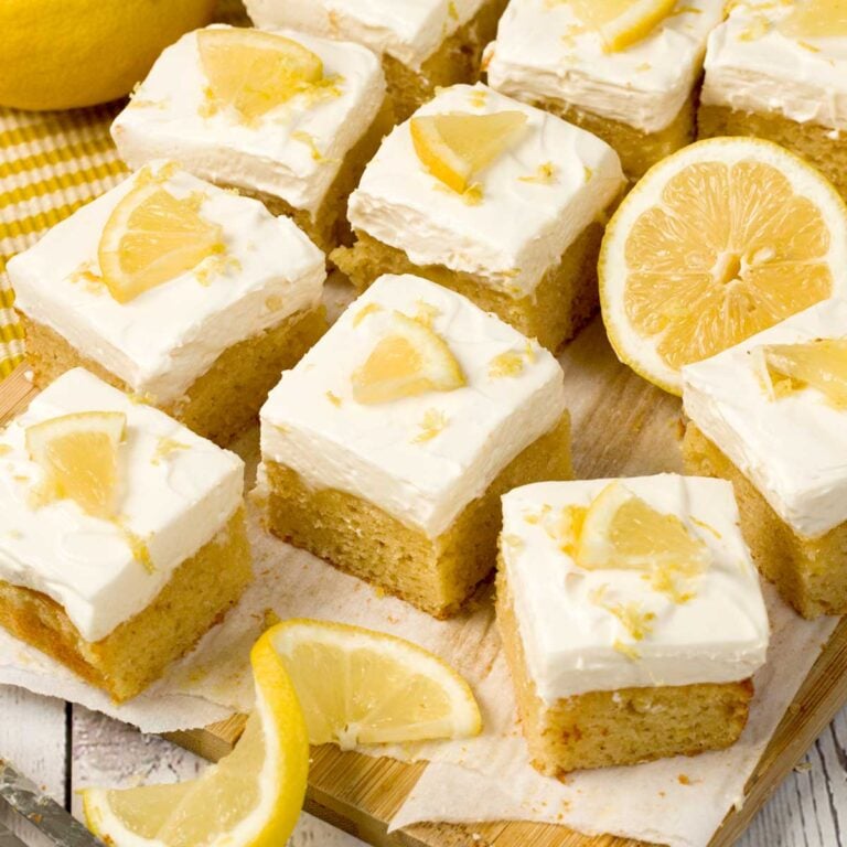 Cassava flour lemon cake with lemon curd and whipped cream cheese frosting on a kitchen counter.