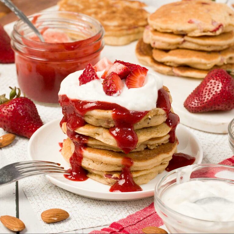 Stack of gluten-free strawberry pancakes on a plate.