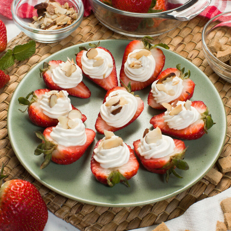 Cream cheese filled strawberries on a plate.