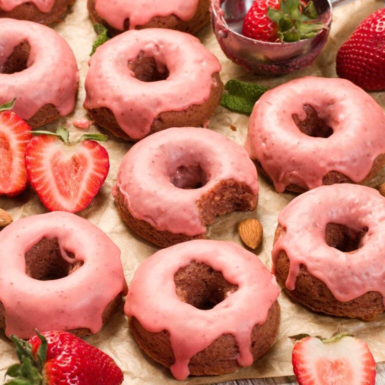 Gluten-Free Strawberry Glazed Donuts on a parchment paper.