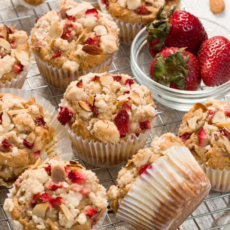 Gluten-free strawberry cream cheese filled muffins with crumble topping on a cooling rack.