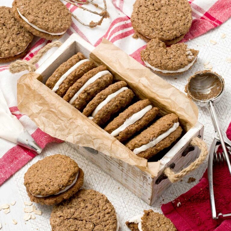 Stack of gluten-free oatmeal cream pies in a white box on a kitchen counter.