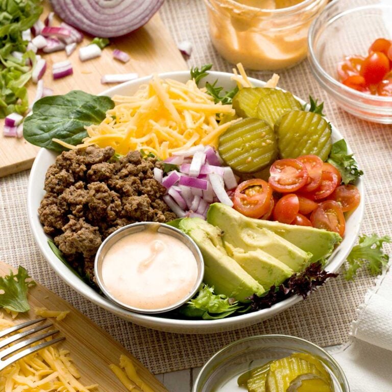 A delicious big Mac bowl with ground beef, cheddar cheese, pickles, tomatoes, red onions, avocado slices, and special big Mac sauce.
