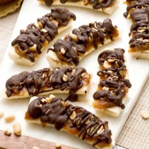 Frozen banana Snickers with date caramel, peanuts and a drizzle of chocolate on top as a healthy candy bar substitute.