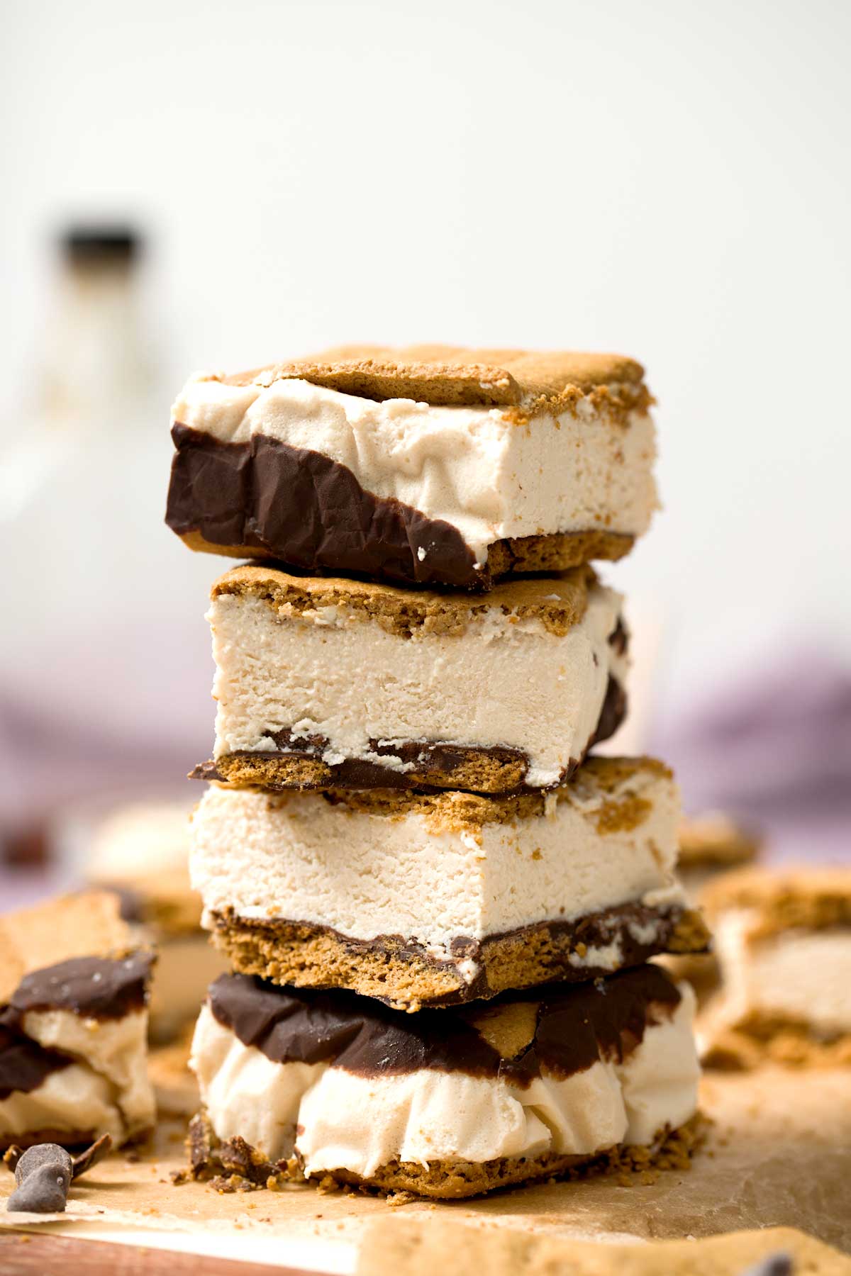 A stack of frozen s'mores protein ice cream sandwiches with melted chocolate