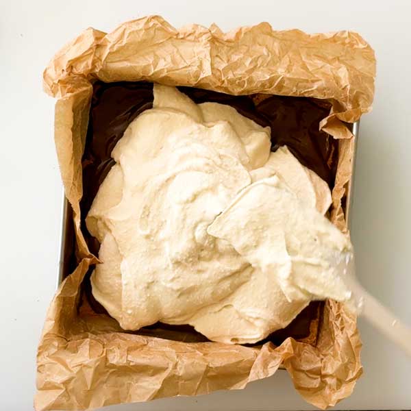 Spreading the cottage cheese ice cream layer in the square pan.