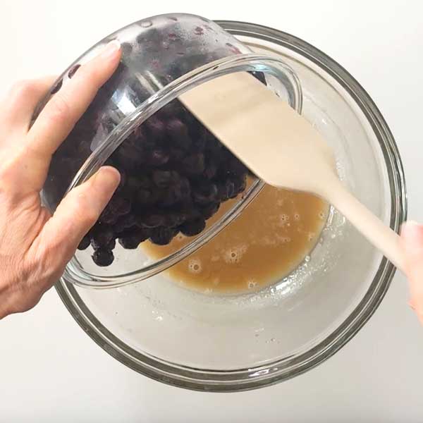 Adding the blueberries to the slurry in the mixing bowl.