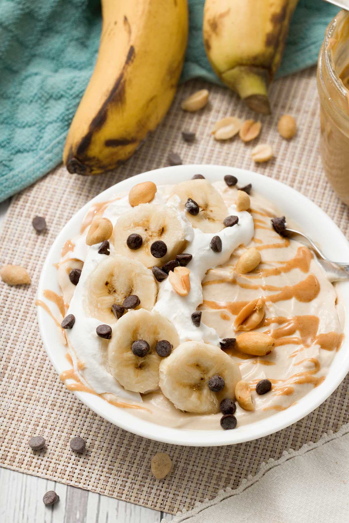 A bowl of peanut butter Greek yogurt with bananas and chocolate chips.