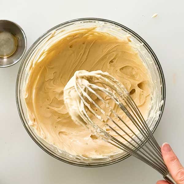 Whisking all the yogurt ingredients in a bowl with a whisk.