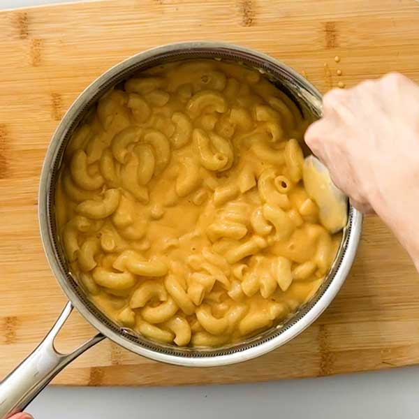 Stirring the pasta in with the cheese sauce.