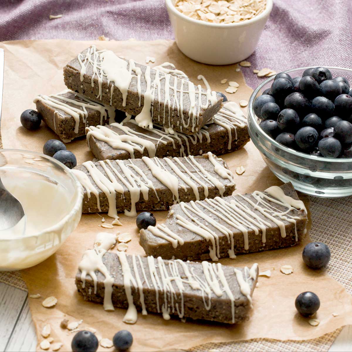 Gluten-free blueberry protein bars with a white chocolate drizzle on top.