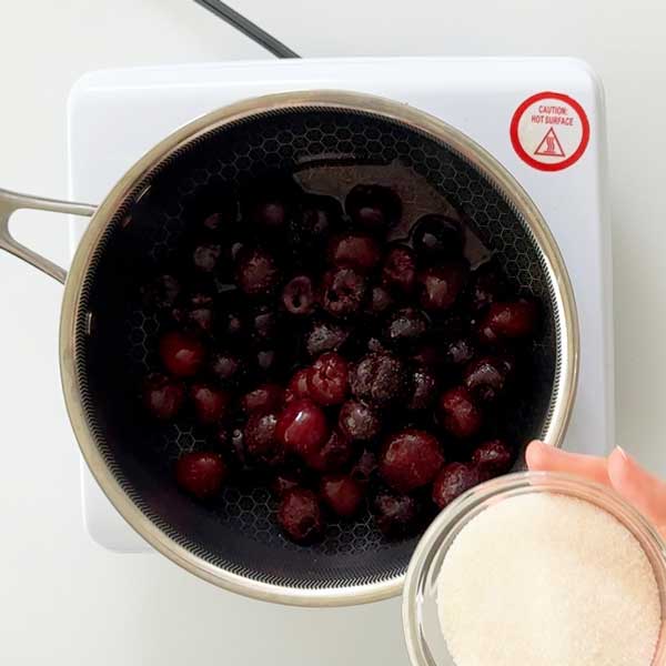 Adding the fresh or frozen cherries to a sauce pan.