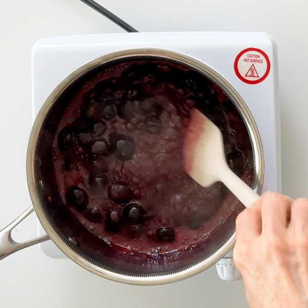 Simmering the cherry compote for ten minutes until cherries are soft.
