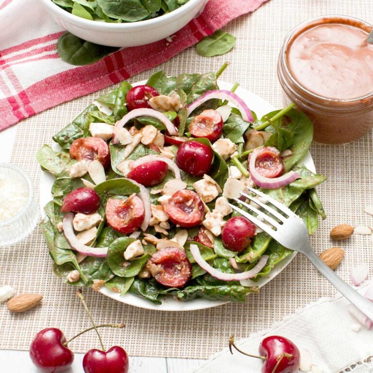 A tossed cherry spinach salad with feta cheese, almonds and red onion and a cherry balsamic vinaigrette.