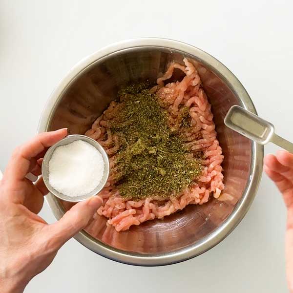 Adding all the seasoning to the ground chicken.