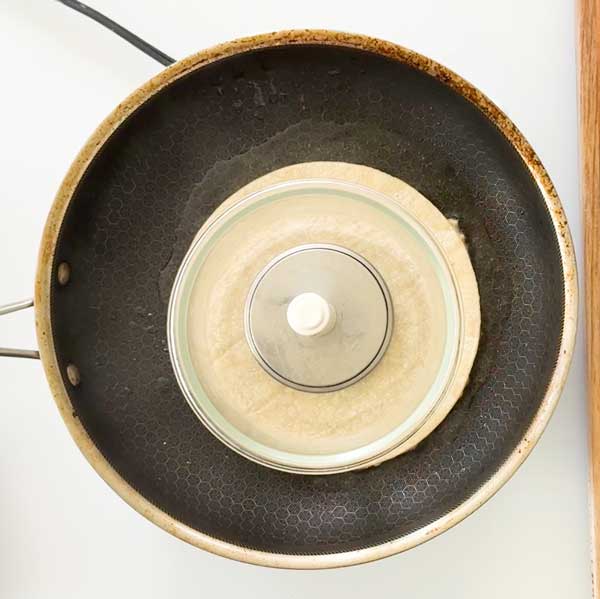 Cooking the smash taco with a glass bowl on top.