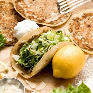 A chicken caesar smashed taco with caesar salad.