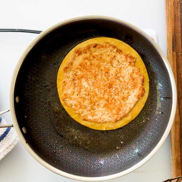 Flipping over the chicken smashed taco in the skillet to toast the bottom of the tortilla.