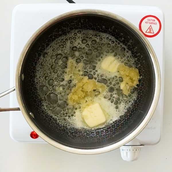 Adding the garlic and Italian seasoning to the melted butter in the saucepan.