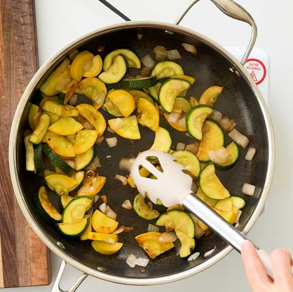 The sautéed zucchini and onions in the skillet.