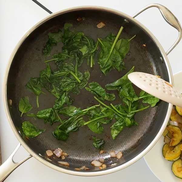 The spinach wilted in the skillet.