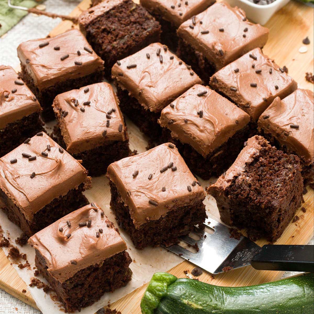 Slices of gluten-free chocolate zucchini cake with cream cheese frosting on top.