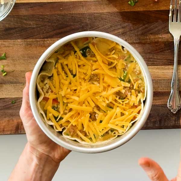 Sprinkling the cheese over the top of the quiche.