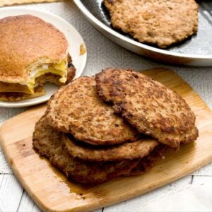 A stack of turkey breakfast patties on a board with maple sausage seasoning.