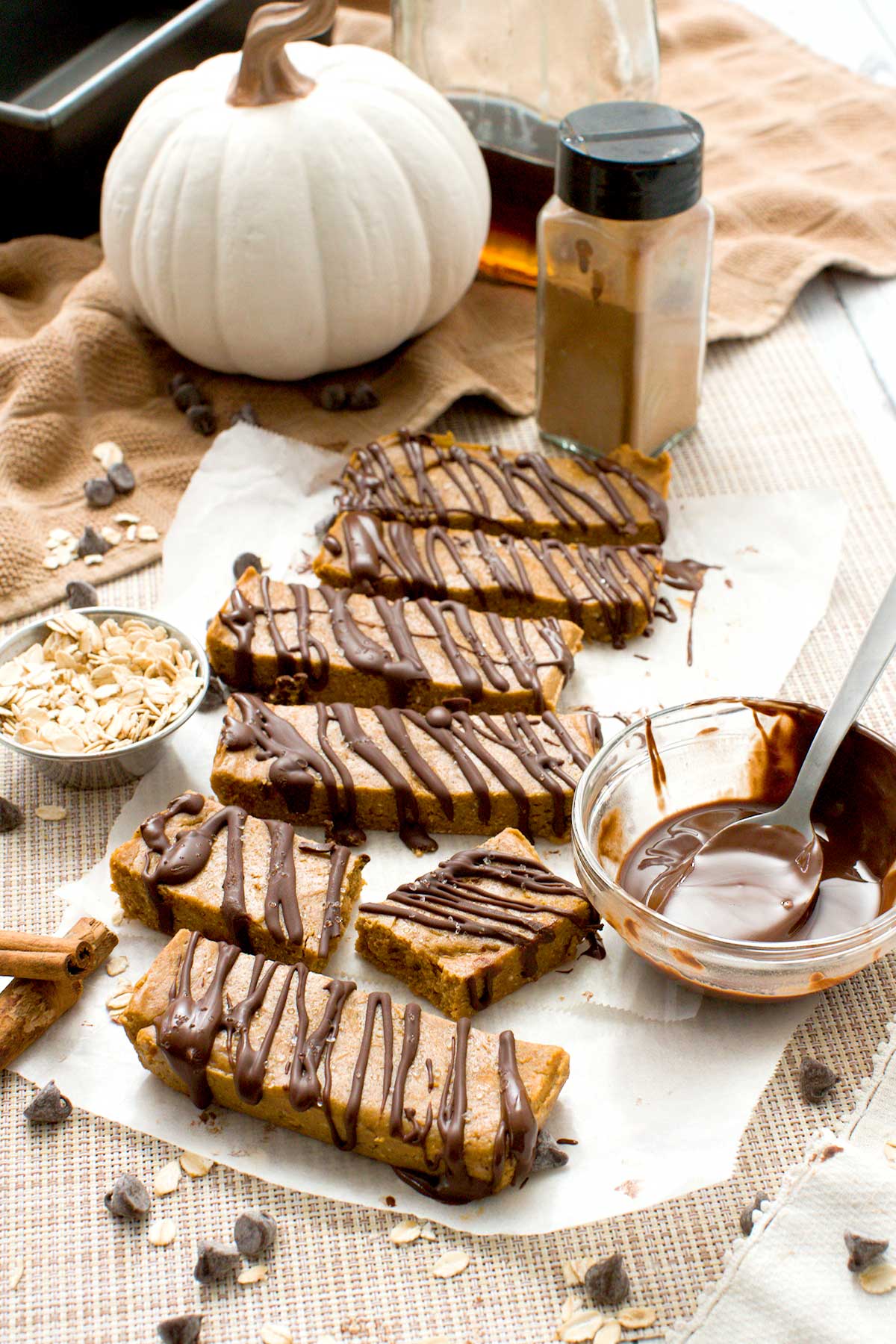 Gluten-free pumpkin protein bars with chocolate drizzle on top and oat flour.