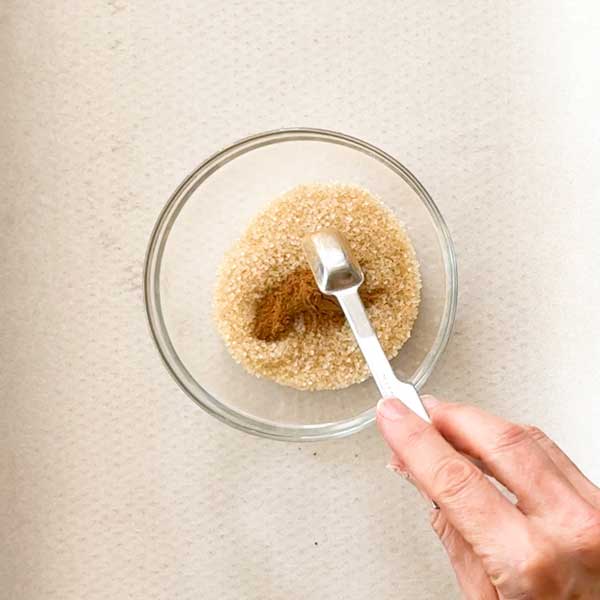 Combining the cinnamon and sugar in a bowl.