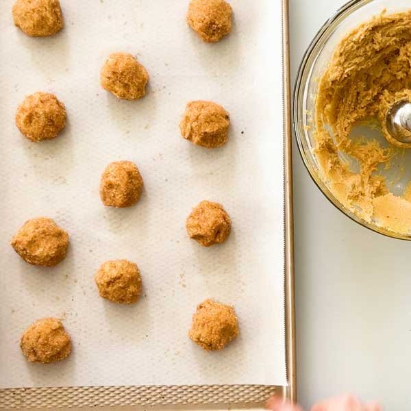 Rolled cookies placed on the parchment paper lined cookie sheet.