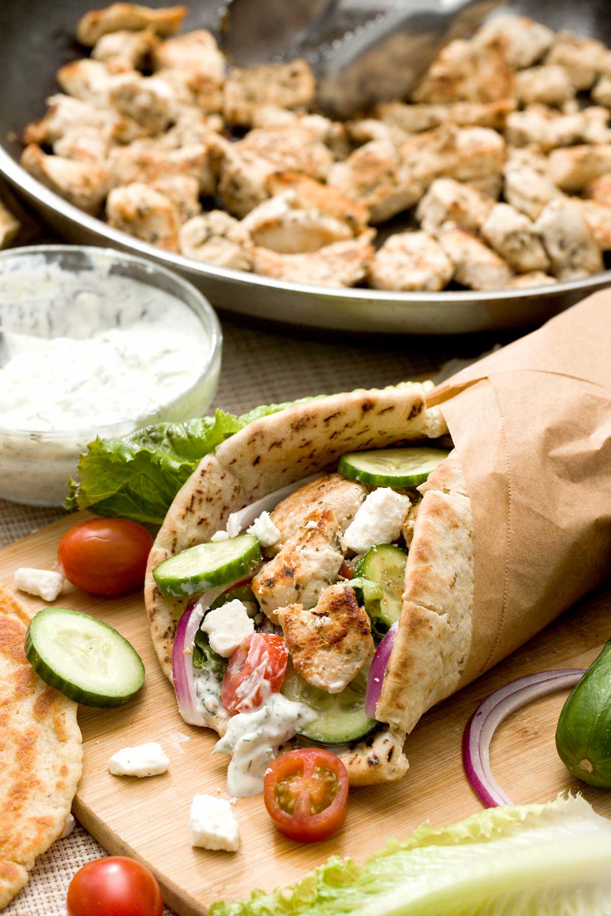 A rolled-up Greek yogurt chicken breast gyro with homemade tzatziki sauce and optional gluten-free naan or pita bread.