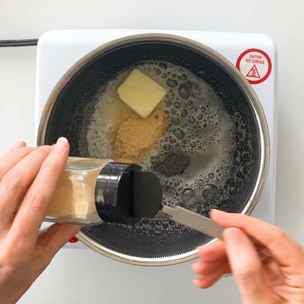 Adding the garlic powder to the sauce pan.