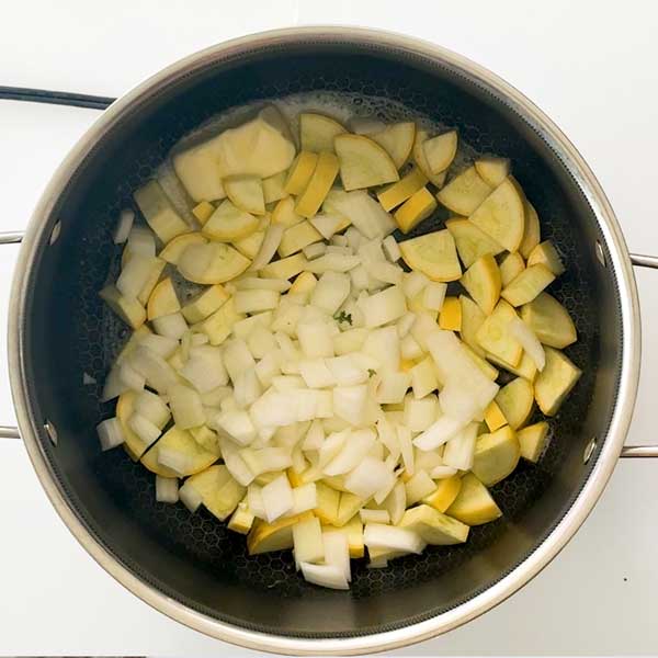 Sauteeing the onions, yellow squash and garlic in the pot.