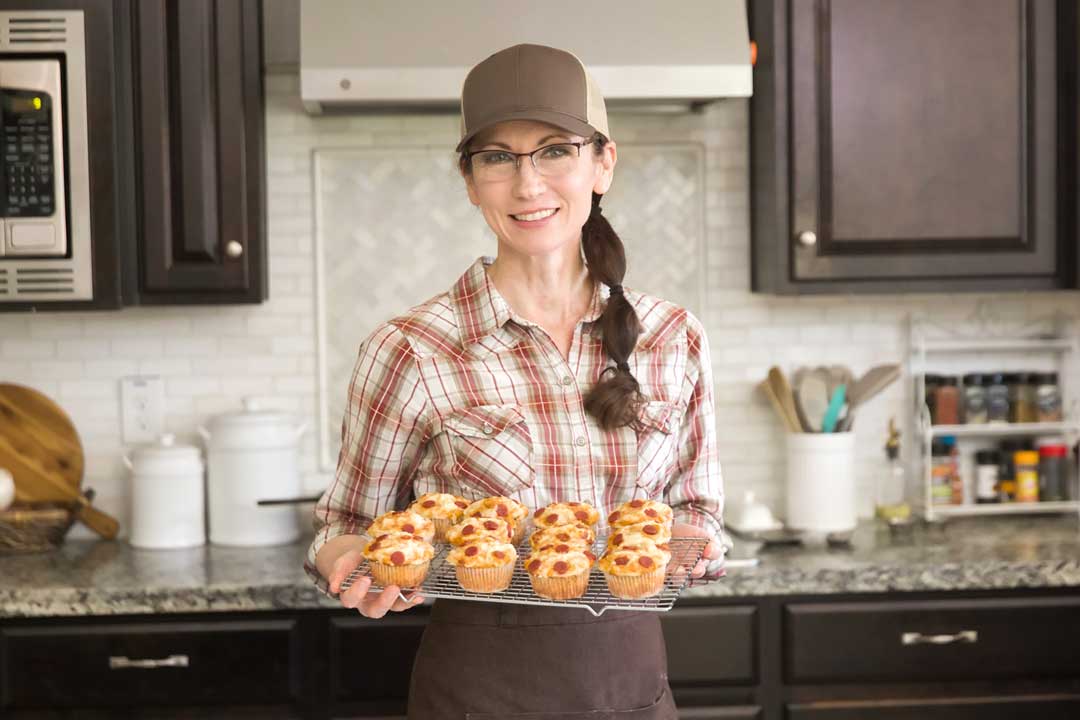Nicole holding a batch of gluten-free pizza muffins.