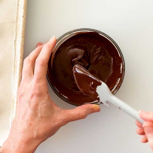 Stirring the melted chocolate until smooth.