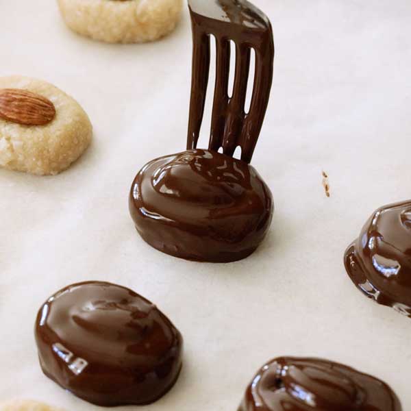 Placing the chocolate dipped bar on the parchment paper.