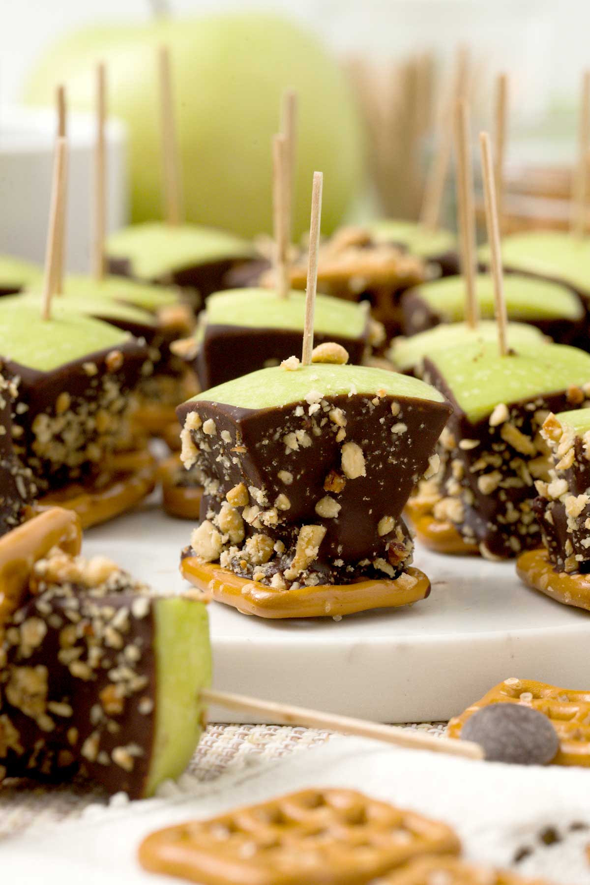 A close-up of a caramel apple pretzel bite with medjool dates and peanuts.