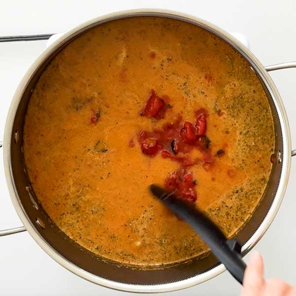 Stirring in the fire-roasted tomatoes to the soup.