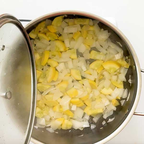 Sauteeing the onion, yellow squash and garlic in the pot.