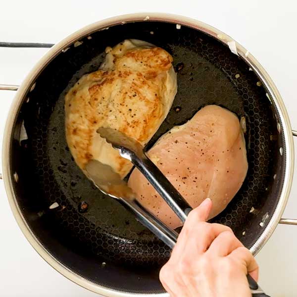 Pan-searing both sides of the chicken in the pot.