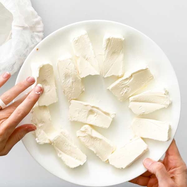 Softening the cream cheese in a plate in the microwave.