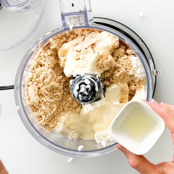 Adding all the cheesecake filling ingredients to a food processor.